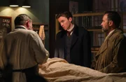 Pathologe Dr. Julius Jaeger (Robert Reinagl, l.) erklärt Max Liebermann (Matthew Beard, M.) und Oskar Rheinhardt (Juergen Maurer, r.) die Verletzung der toten Schauspielerin Ida.