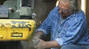 Der Mechaniker poliert das Metallteil.