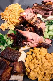 Originale amerikanisches Kansas City-Barbecue mit Fleisch das 12 Stunden im Smoker verbracht hat und passenden Beilagen.