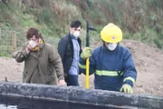 DCI Vera Stanhope (Brenda Blethyn) und ihr Assistent DS Aiden Healy (Kenny Doughty; M.) sind bei der Bergung des Toten, der im Jauche-Becken liegt, dabei.