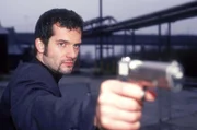 Beck (Martin Rapold) bedroht Natalie mit einer Waffe...
