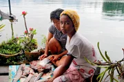 Die Töchter der Fischerfamilien am thailändischen Khao-Sok-See nehmen den Fang aus.