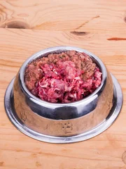 Fresh nutritious and delicious minced raw meat and bone dog food in bowl