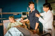 Ole (Anton Rubtsov, l.) will Tim (Constantin Lücke, M.) nicht sehen. Dr. Jonas (Gerit Kling, r.) sorgt dafür, dass Tim das Patientenzimmer verlässt.