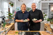 Die zwei Starköche Alexander Herrmann (rechts) und Björn Freitag strahlen hier um die Wette mit einem Lecker-Happen in der Hand: "Eggs Björn".