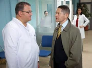 Hans-Peter Brenner (Michael Trischan, links) folgt mit einem mulmigen Gefühl Elena Eichhorns (Cheryl Shepard, hinten rechts) Rat: Er fragt Dr. Kaminski (Udo Schenk), ob dieser ihm ein paar Übungsstunden für Nahttechniken geben kann. Erwartungsgemäß lässt Kaminski Brenner stehen.
