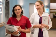Dr. Julia Berger (Mirka Pigulla, r.) witzelt mit ihrer jüngeren Halbschwester Dr. Rebecca Krieger (Milena Straube, l.).