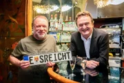 Hanno Settele steht mit Schauspieler und Dok1 Protagonisten Reinhard Nowak an der Bar des Filmcasinos bei einem Glas Sekt.