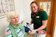 Landärztin Diane Lorenz-Pferdmenges beim Blutdruckmessen mit einer Patientin - Alltag in der Praxis.