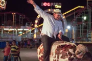 Tony Diniz riding a bucking bronco at the Expo Argo Country Fair in Governadaor Valadares.