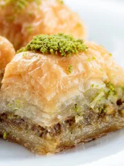 Baklava with pistachios and walnuts on white plate. Shallow depth of field