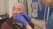 Close up of Dr Emma’s hands inspecting Kevin Sullivans nose Rhinophyma.