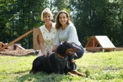 Marlies Lochmann und Andrea Schlager posieren für ein Foto mit Dobermann Dante.