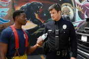 John Nolan (Nathan Fillion, r.) und Feuerwehrbeamter Antonio (Mitchell Edwards, l.) arbeiten bei einem Einsatz zusammen.
