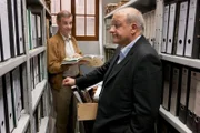 Manni (Heinrich Schafmeister, li.) und Wilsberg (Leonard Lansink) sehen die alten Akten der Dralling- Chemie durch.
