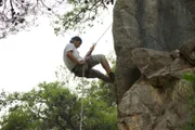 Farouk abseiling down a cliff.