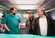 Dr. Oliver Körfer (Peter Trabner, l.) klärt Günter Hoffmann (Wolfgang Winkler, r.) und Edwin Bremer (Tilo Prückner, M.) über die Todesursache von Erna Renner auf.