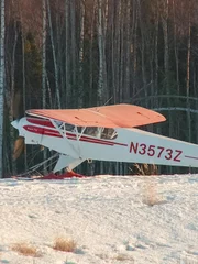 Piper Cub sits in snow.