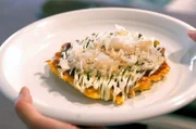 In Osaka bereitet Maya eine Art Kohl-Pfannkuchen zu: Die Okonomiyaki serviert sie mit einer speziellen Soße und Katsuobushi-Flocken.