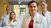 Die Assistenzärztin Dr. Rebecca Krieger (Milena Straube, 2.v.r.) ist begeistert, als sie hört, dass sie am „Umgekehrt-Tag“ wie eine Fachärztin den Ton angeben darf, denn sie ist mit ihrer Schwester Dr. Julia Berger (Mirka Pigulla, r.) zu einem spannenden Fall eingeteilt. Für Luisa Fuchs (Sarah Buchholzer, 2.v.l. mit Komparsin) steht die Operation einer Nierenbeckenplastik an.