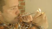 'Tom' takes a hit from a home made crack pipe.