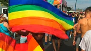 Mann schwingt Regenbogenflaggen auf gay pride Festival in Berlin.