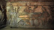 Charakteristisches Wandrelief in altägyptischen Gräbern: Der schakalköpfige Totengott Anubis bei der Mumifizierung eines Leichnams.