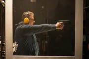 Der Mann hat eine Waffe in der Hand