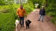 Coach Andreas Ohligschläger (r) zusammen mit Hundehalterin Kerstin und ihren beiden Hunden Maya und Otto (cremefarbener Labrador)