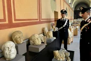 Carabinieri stehen neben geborgenen archäologischen Artefakten in Rom.