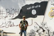 Ein Mitglied der von der Türkei unterstützten Freien Syrischen Armee (FSA) steht am 31. August 2016, Syrien, vor einer ISIS-Flagge in der Grenzstadt Jarablus.