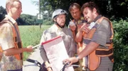 Benno (Willi Thomczyk, r.), Lothar (Rene Heinersdorff, 2.v.r.) und Fiete (Nicholas Bodeux, l.) erklären Pröter (Wilfried Herbst), dass der Verkehr hier umgeleitet wird, da sie eine Überquerungshilfe für Kröten bauen.