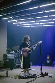 Nilüfer Yanya singt und spielt Gitarre auf der Bühne.