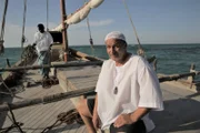 Men on a boat near Jazirat al Hamra, a desert town in UAE.