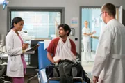 Emma (Elisa Agbaglah, l.) und Elias (Stefan Ruppe, r.) kümmern sich um ihren aufgeweckten Patienten Alexander Haag (Daniel Popat, M.).