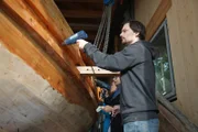David Hanselmann mit einem Heißluftgebläse auf dem römischen Schiffsnachbau in der Werkstatt in Gunzenhausen, Deutschland.