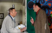 Alois bekommt seine Lektion, als wegen seiner schlechten Laune ein Marktforscher mit der Auflösung des Poststellen-Vertrags droht. Von links: Alois Preissinger (Erich Hallhuber sen.) und der Post-Marktforscher (Falk Rößler).
