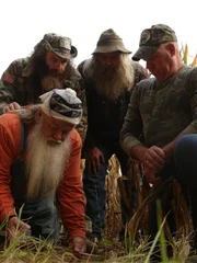 AIMS Team inspecting evidence at edge of corn field.