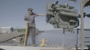 YUKON RIVER, ALASKA- Austin guides the new engine into the boat.