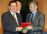 Der designierte Bundeskanzler Gerhard Schröder (l.) und der designierte Außenminister Joschka Fischer (r.) von den Grünen präsentieren nach der Unterzeichnung den rot-grünen Koalitionsvertrag in der NRW-Landesvertretung in Bonn.