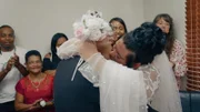 Charlotte & Johan kiss at wedding with family in background