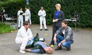 Der Gärtner Christian Schwarz (Komparse, liegend) stirbt an plötzlichem Herzversagen. Rechtsmediziner Dr. Benedikt Förster (Florian Wünsche, l.) äußert gegenüber den Kriminalkommissaren Martina Seiffert (Astrid M. Fünderich) und Jo Stoll (Peter Ketnath, r.) den Verdacht, dass der Mann vergiftet wurde. Findet die Spurensicherung (Komparsen) rund um Jan Arnaud (Mike Zaka Sommerfeldt, Hintergrund 3.v.r.) entsprechend relevante Spuren?