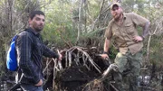 Grady Powell and Bill McConnell next to an upturned tree in a swamp in Cuba.