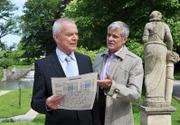 Friedrich (Dietrich Adam, r.) amüsiert sich über Werner (Dirk Galuba, l.), der sich aufgrund seines verpatzen Auftritts beim Fassanstich zum Gespött der Leute gemacht hat.