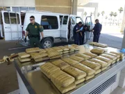 Pharr, Texas, USA: On a table sit bundles of marijuana that were hidden in a van, which is in the background.