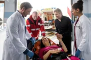 Nancy Lenz (Elisabeth Baulitz, M.) und ihr Mann Kai (Jörg Witte, 2.v.r.) sind unter Alkoholeinfluss zusammen eine Treppe hinuntergestürzt. Dr. Marc Lindner (Christian Beermann, l. mit Komparse, 2.v.l.) und Vivienne Kling (Jane Chirwa, r.) kümmern sich um die erheblich verletzte, aber gut gelaunte Nancy.