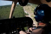 Laredo, TX: A Customs and Border Protection helicopter working with agents below on ATVs.