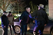 Der Sheriff beruhigt den Mann, während die anderen zusehen.
