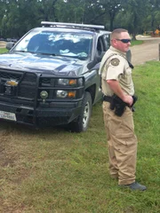 Game Warden Brandt Bernstein standing next to vehicle.