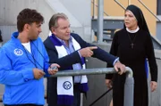 Bürgermeister Wöller erteilt Jupp Helmer letzte Anweisungen vor dem Fußballspiel, Schwester Hanna wundert sich über seinen Eifer.